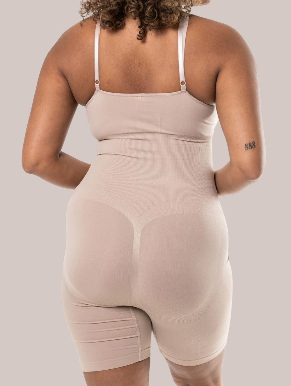 Back view of a model wearing a beige Inshapewear™ seamless shaping bodysuit with adjustable straps.