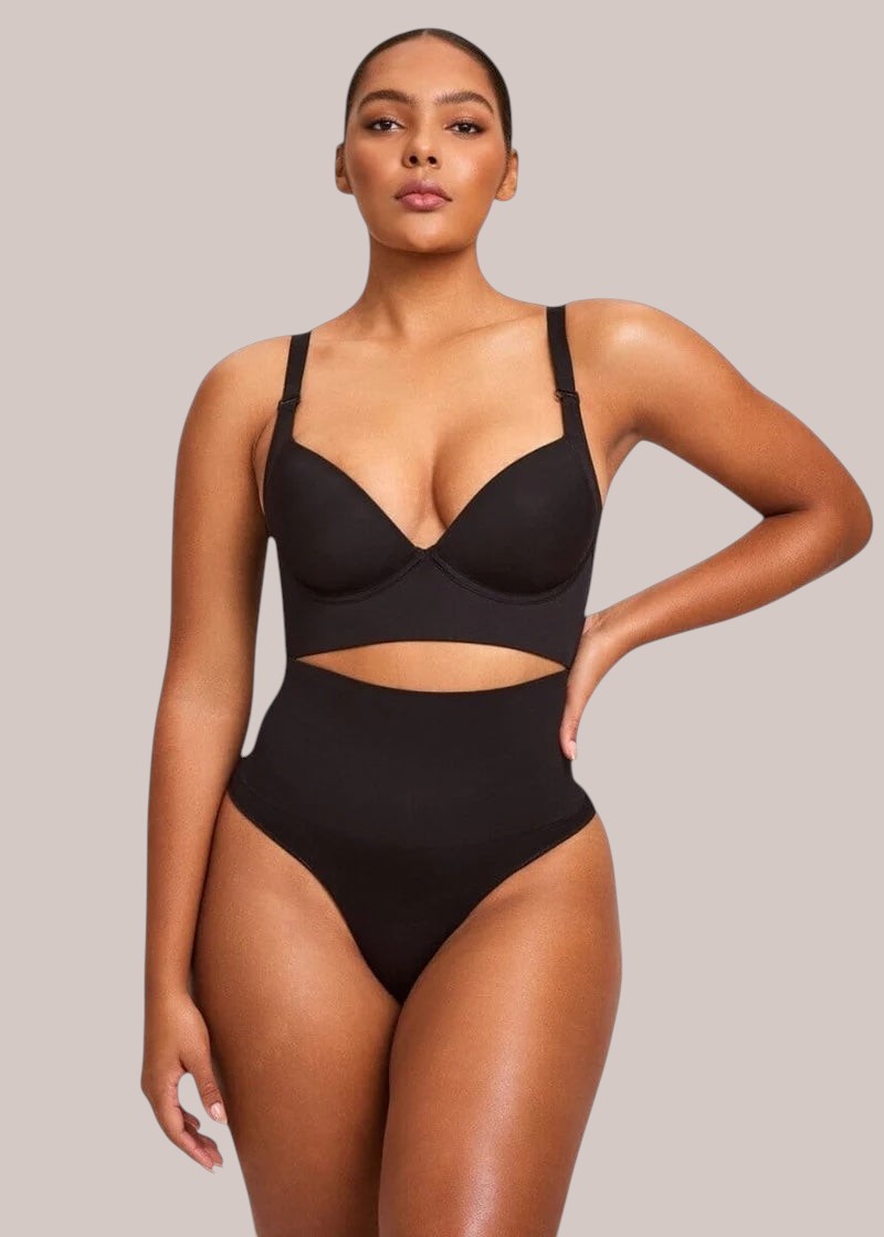 Model wearing a black Inshapewear™ high-waisted shaping bodysuit with a cut-out midriff and adjustable straps