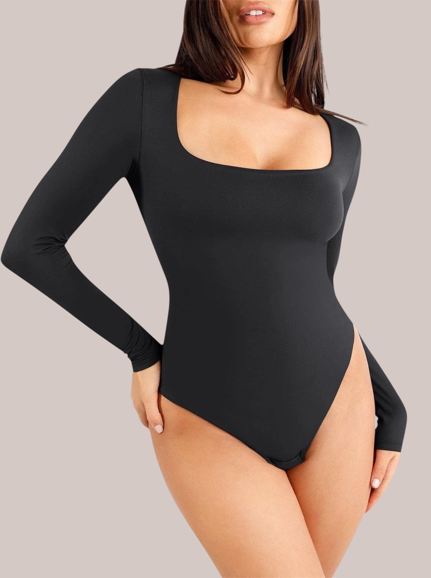 Model wearing a black Inshapewear™ long-sleeve shaping bodysuit with a square neckline and breathable fabric.
