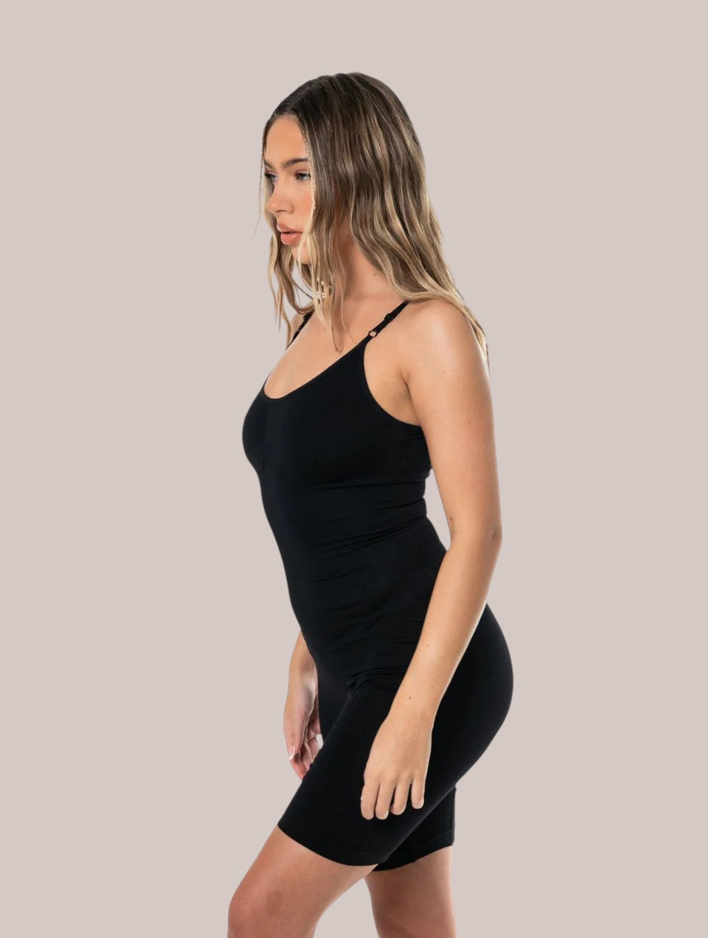 Model wearing a black Inshapewear™ seamless shaping bodysuit with adjustable straps for a smooth silhouette