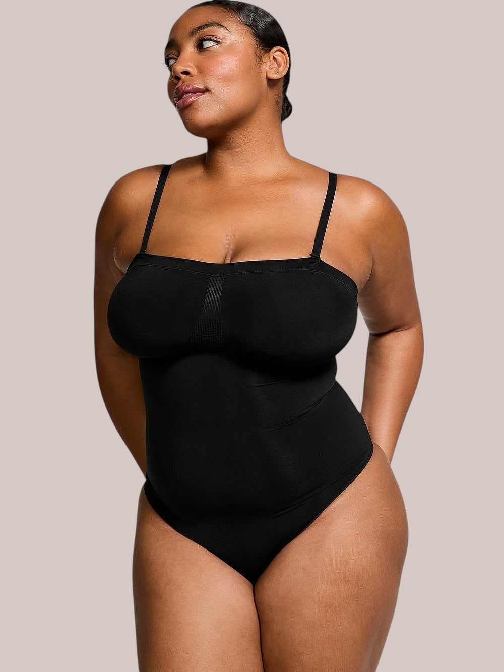 Model wearing a black Inshapewear™ shaping bodysuit with detachable straps for a smooth silhouette
