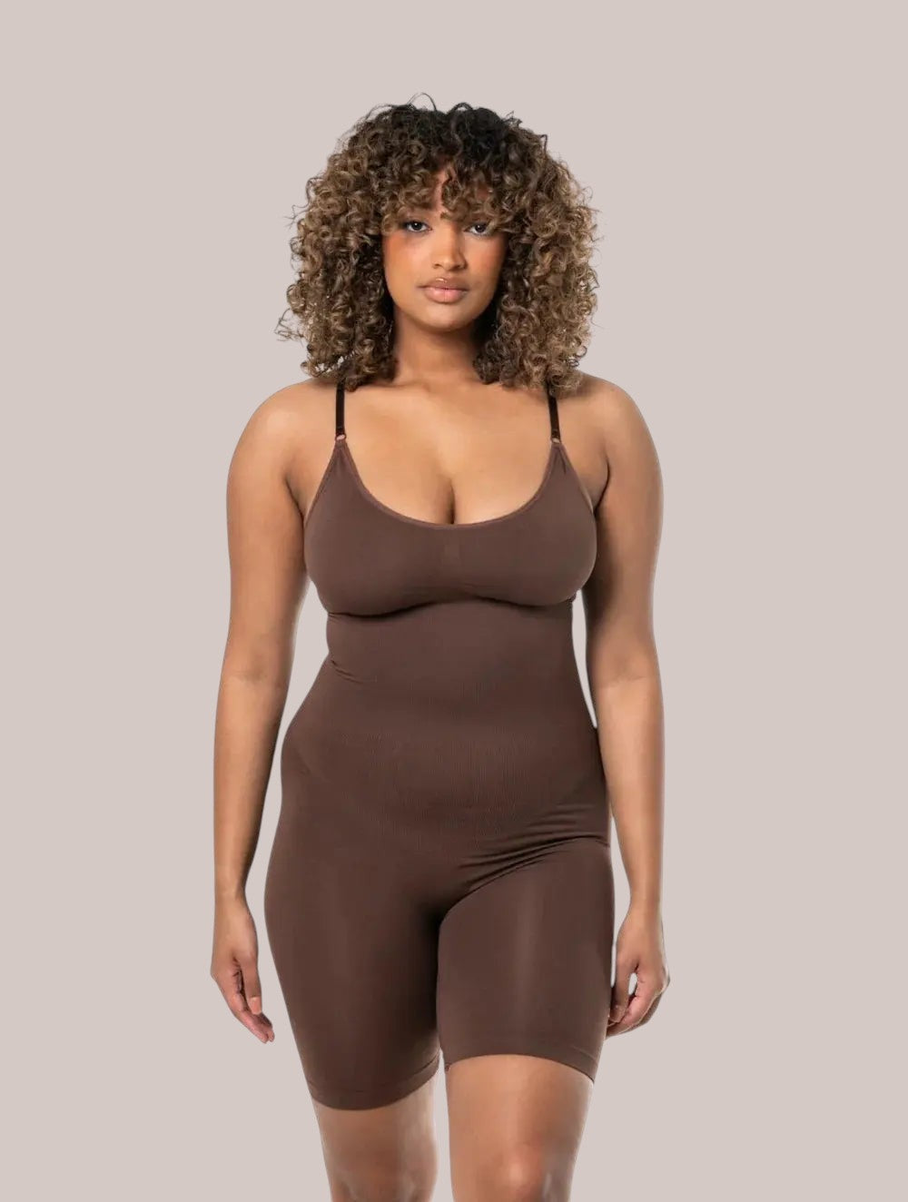 Model wearing a brown Inshapewear™ seamless shaping bodysuit with adjustable straps for a smooth silhouette.