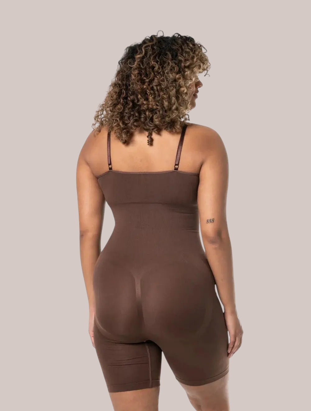 Back view of a woman wearing a brown Inshapewear™ seamless shaping bodysuit with adjustable straps.