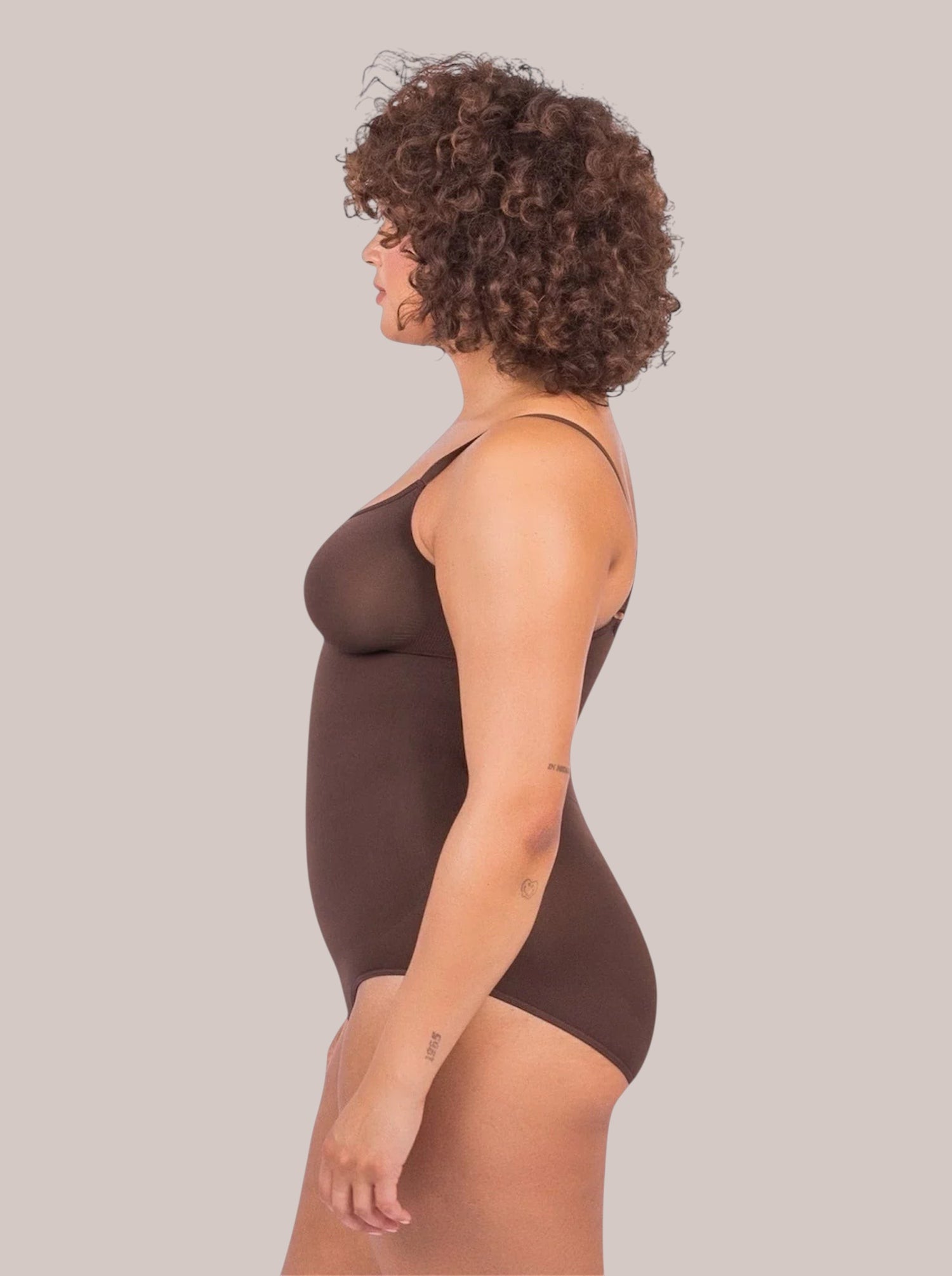 Model wearing a brown Inshapewear™ elegant shaping bodysuit with targeted compression for a smooth silhouette.