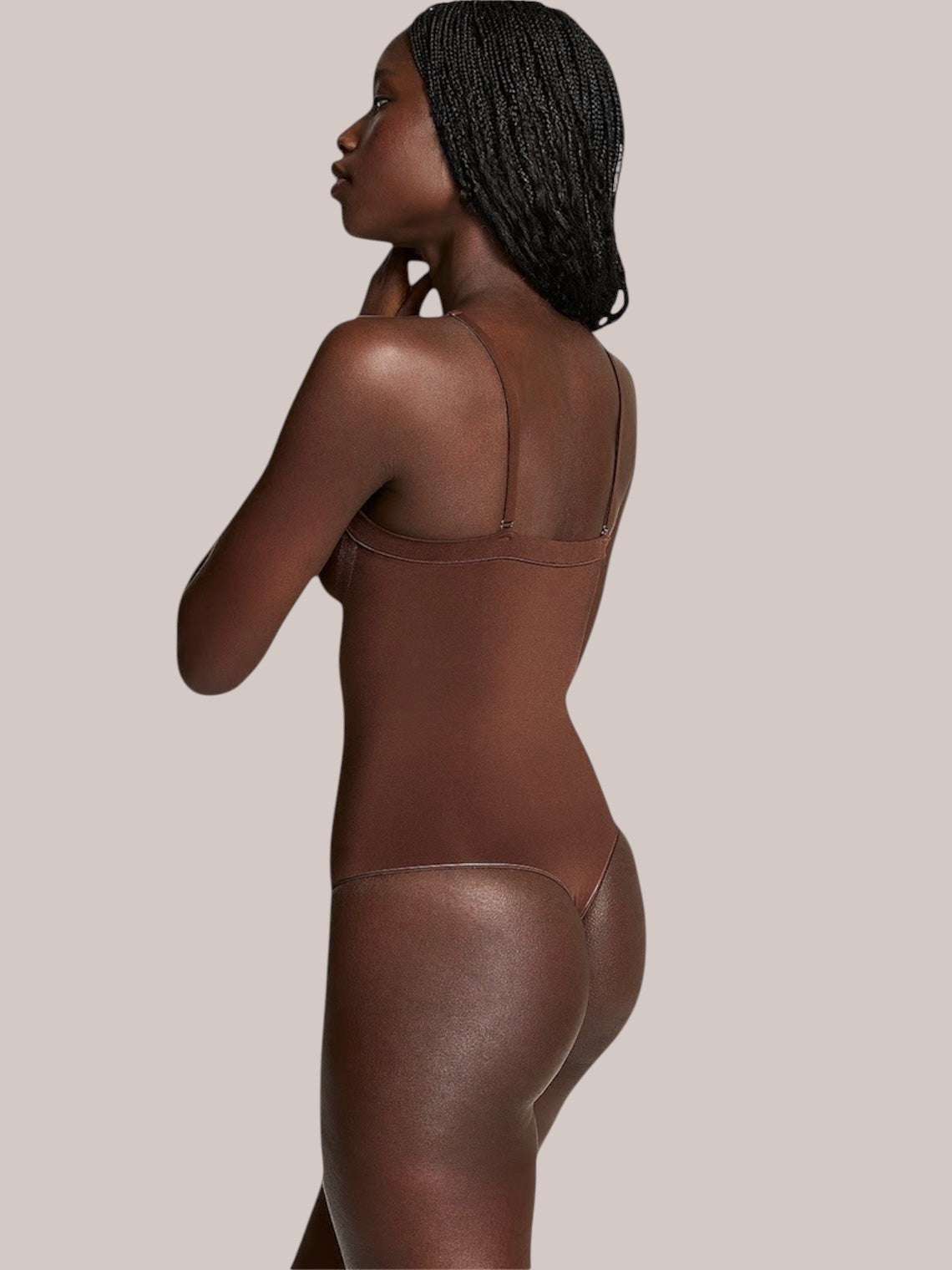 Model wearing a brown Inshapewear™ shaping bodysuit with thin detachable straps and a thong back design