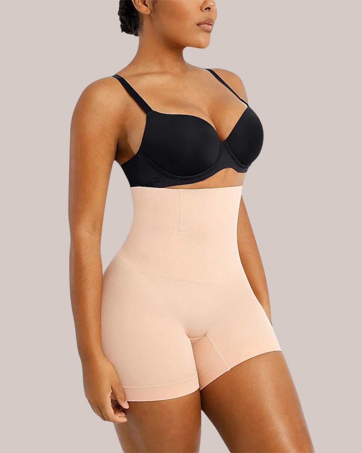 Model wearing Inshapewear™ high-waisted beige shaping shorts for a smooth silhouette under clothing.