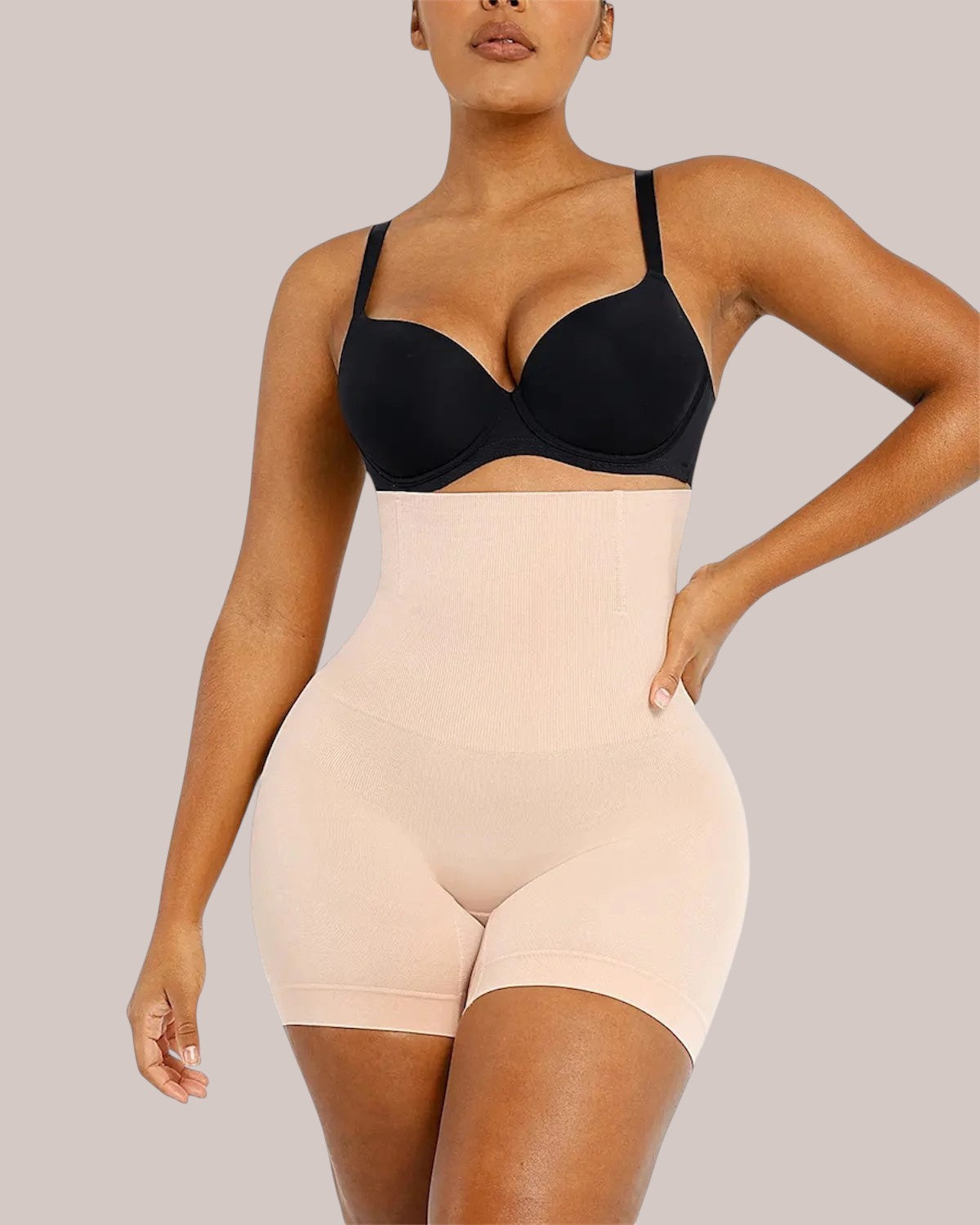Model wearing Inshapewear™ high-waisted beige shaping shorts for a smooth silhouette and tummy control effect
