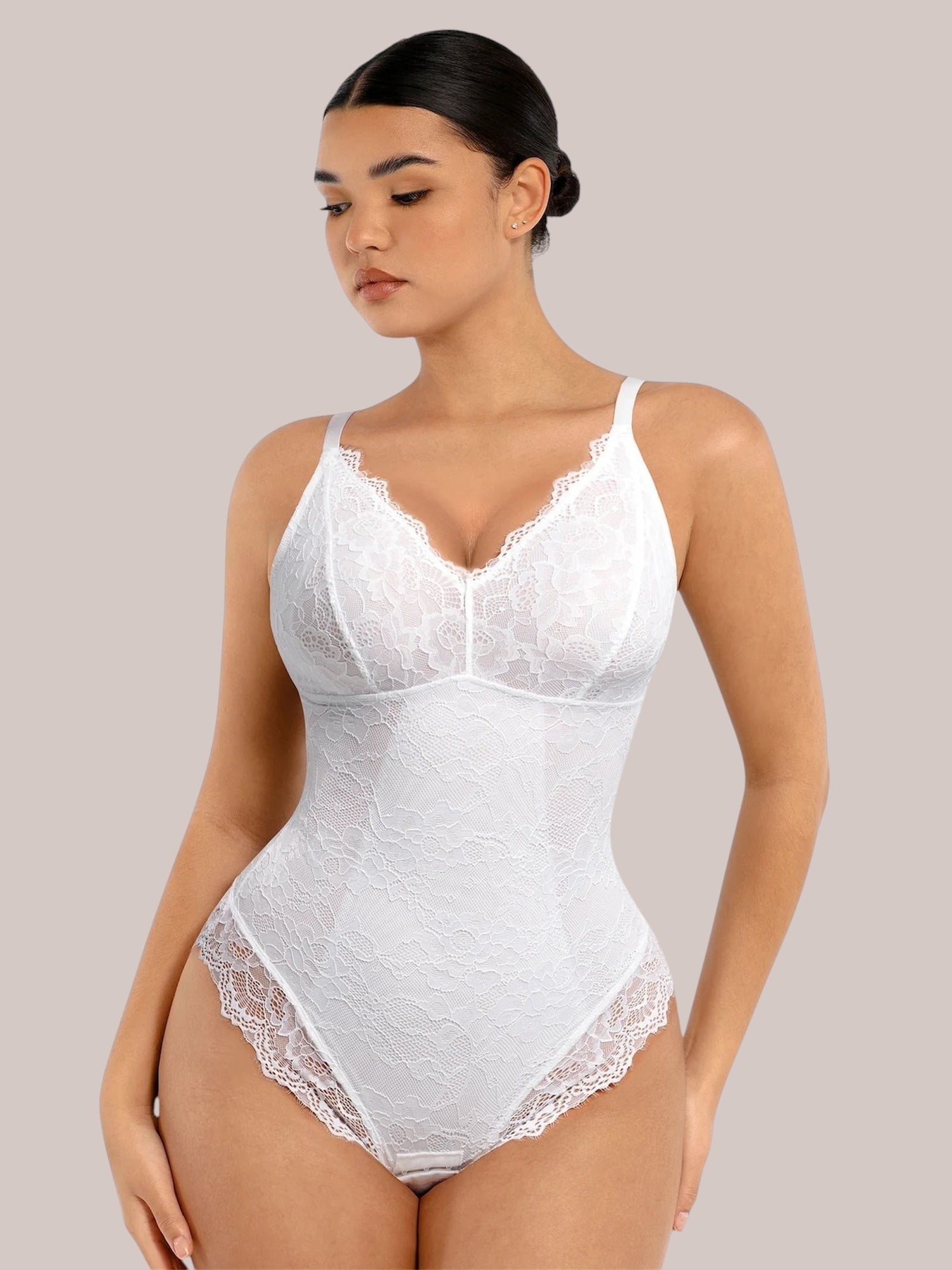 Model wearing a white Inshapewear™ lace bodysuit with a V-neckline and delicate scalloped trim details.